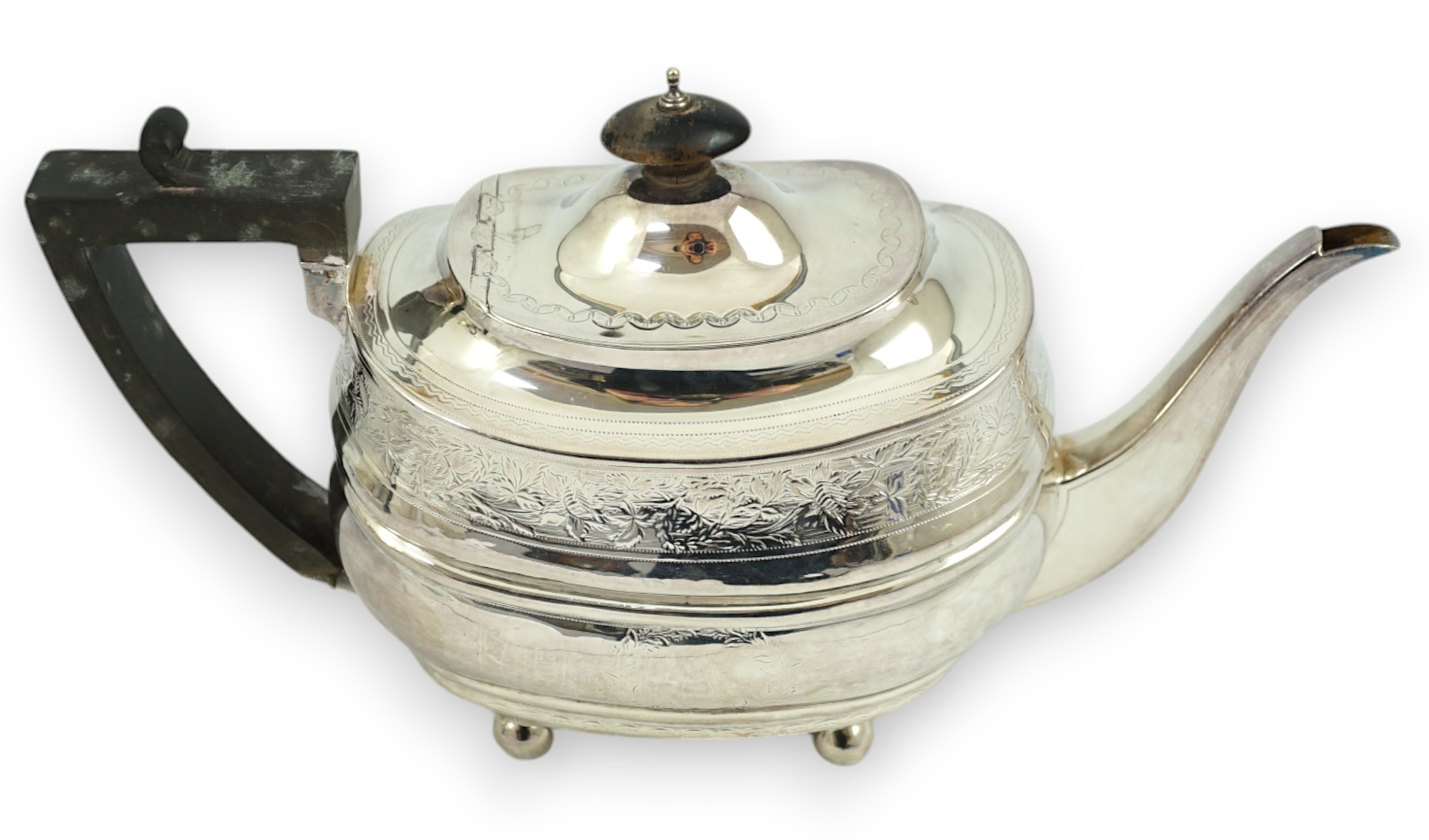 A George III engraved silver shaped oval teapot, on ball feet, Thomas Wallis II, London, 1807, gross weight 16.1oz.